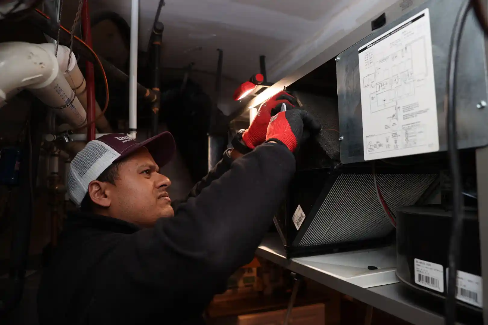 Unionville Heating technician inspecting indoor air quality system in residential furnace