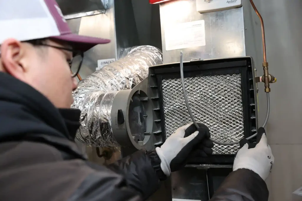 Unionville Heating technician installing air cleaner filter in residential HVAC system