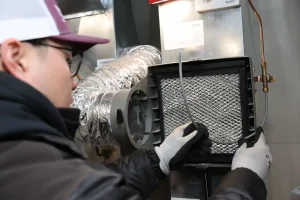 Unionville Heating technician installing air cleaner filter in residential HVAC system