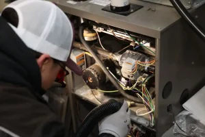 Unionville Heating technician performing furnace maintenance and motor inspection