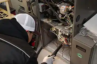 HVAC technician inspecting the internal components of a furnace